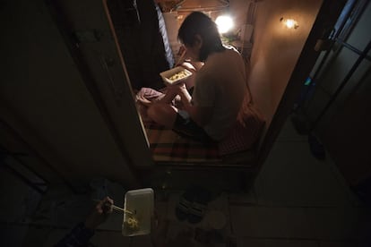 Un residente cena en el interior de su hogar ataúd.