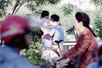 Una pareja de jóvenes se abraza en una calle de Tianjin (China).