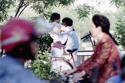 Una pareja de jóvenes se abraza en una calle de Tianjin (China).