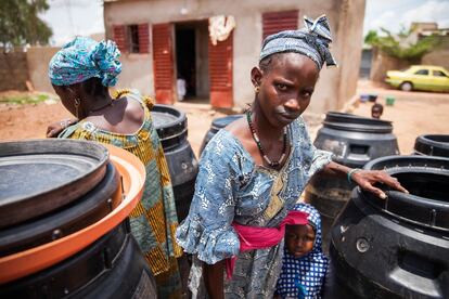Dos jovenes Peul cogen agua de los depositos donde la almacenan para su uso cotidiano.