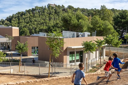 Unos niños juegan este miércoles en el colegio Serra Calderona, en Gilet, situado al lado del parque natural que lleva por nombre. Su diseño ha tratado de que no desentone en el entorno y se han utilizado en la medida de lo posible materiales de la zona, y árboles y plantas adaptadas al clima del lugar.