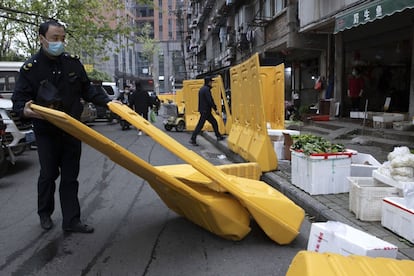 Un empleado del Ayuntamiento de Wuhan retira el vallado que durante más de dos meses sirvió para confinar a la población y evitar que accedieran a comercios y lugares públicos. La imagen es del 5 de abril. La ciudad se preparaba el pasado domingo para volver a la normalidad con el fin de la cuarentena.