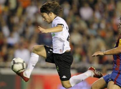 Silva se lleva el balón ante Puyol.