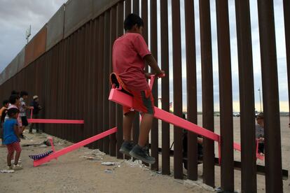 Famílias americanas e mexicanas brincam em um balanço instalado no muro entre o México e Estados Unidos, em Ciudad Juárez, em 28 de julho de 2019. Nos EUA de Donald Trump, a imigração é uma ameaça à segurança nacional. O republicano, que lançou em 2015 sua candidatura à Casa Branca culpando o México pela “entrada de drogas, criminosos e estupradores”, definiu o muro fronteiriço como um dos pilares centrais de seu plano de segurança.