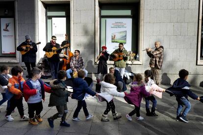 Una fila de niños pasa por delante del grupo Atacapaca, en el centro de Madrid.