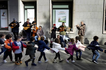 Una fila de niños pasa por delante del grupo Atacapaca, en el centro de Madrid.