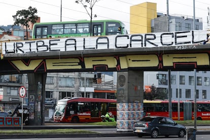Un cartel colgado en un puente peatonal en contra del expresidente Álvaro Uribe este lunes, en Bogotá