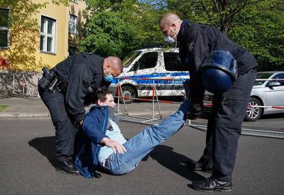 La policía detiene a un manifestante en una marcha improvisada en Berlín con motivo del Primero de Mayo. El Día del Trabajo se conmemora este año en un espacio global, Internet, y con reivindicaciones muy similares en todo el planeta debido al coronavirus que está provocando una fuerte caída del empleo.