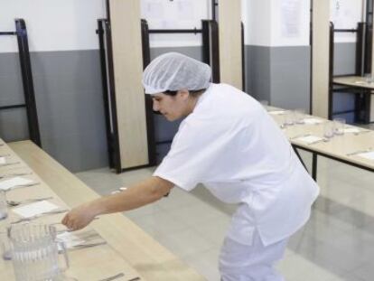 Dos trabajadoras preparan el comedor de un centro escolar.