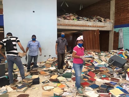 Un grupo de personas acomoda los libros de la Universidad de Oriente de Venezuela.