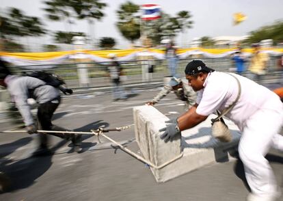 Un grupo de manifestantes retira esta ma&ntilde;ana las barricadas de las calles de Bangkok (Tailandia) tras permitirles la polic&iacute;a el acceso al Parlamento. 