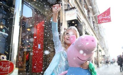 Una ni&ntilde;a con un peluche de Pepa Pig frente a la tienda de juguetes Hamleys, en Londres.