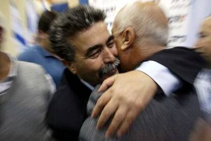 El nuevo presidente del Partido Laborista de Israel, Amir Peretz, abraza a un alcalde ayer en Tel Aviv.