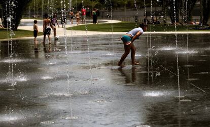 Gente mojandose en los chorros en Madrid Río, ante la ola de calor.