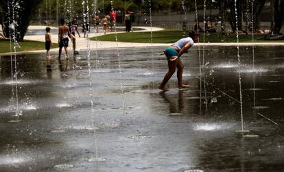 Gente mojandose en los chorros en Madrid Río, ante la ola de calor.