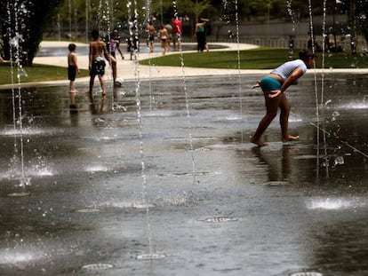 Gente mojandose en los chorros en Madrid Río, ante la ola de calor.