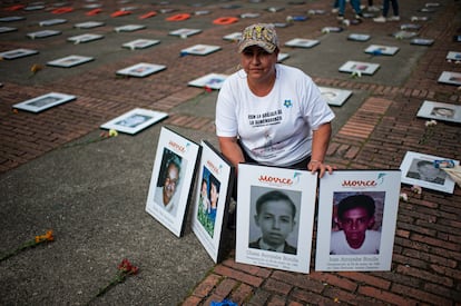 Una mujer con retratos de su padre y hermano, víctimas de desaparición forzada, en Bogotá.