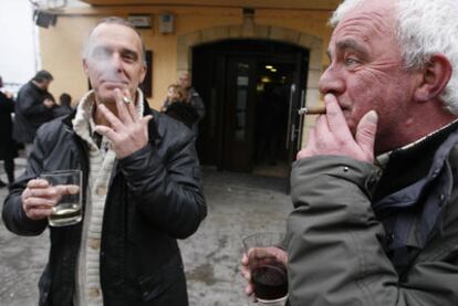 Dos hombres fuman en el exterior de un bar en la calle San Pedro de Hondarribia.