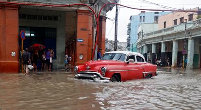 Un automóvil transita por una calle inundada en La Habana.