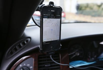 Un m&oacute;vil instalado en un coche muestra la aplicaci&oacute;n de Uber 