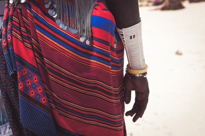 Una de las cosas que más reseñan quienes viajan a Tanzania es el colorido. Así que nada mejor que hacerte con alguna tela africana. No es difícil encontrarlas a un precio cercano al euro, tras el regateo de rigor. Y, además, por un poco más, y tras tomar las medidas oportunas, pueden hacerte casi cualquier prenda en un par de días. Eso sí, si son pañuelos masais el precio puede subir hasta casi los dos euros. <br> En la imagen, una mujer masai vestida con las telas típicas africanas.