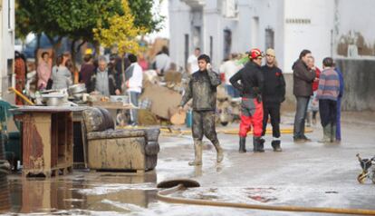 Vecinos de Écija trabajan contra el lodo, un día después de las fuertes lluvias sobre Écija.