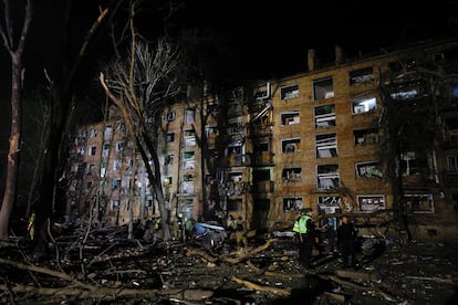 Personal de emergencias trabajan junto a los escombros de un bloque de viviendas tras un ataque ruso sobre Kiev, este jueves. 