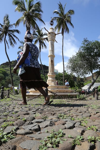 Mulher caminha em frente ao pelourinho da Cidade Velha (Cabo Verde), um lugar onde os negros escravizados eram castigados.