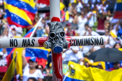 Un manifestante sostiene una cruz en Miami, durante la concentración de este sábado en la que la comunidad de venezolanos afincados en la Florida salieron a las calles a protestar contra los resultados electorales.  