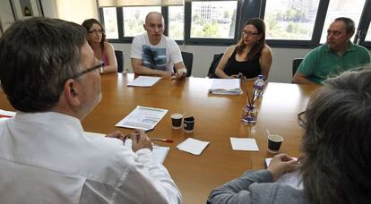 El secretario general del PSPV, Ximo Puig (de espaldas), en la reunión con los afectados por el impago de ayudas a la vivienda.