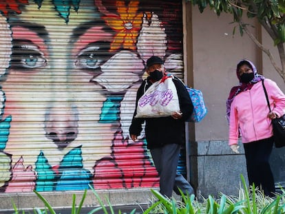 Dos personas caminan frente a locales cerrados durante la crisis del coronavirus en Ciudad de México.