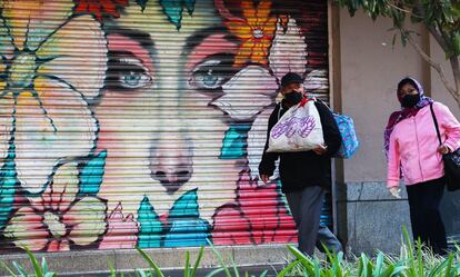 Dos personas caminan frente a locales cerrados durante la crisis del coronavirus en Ciudad de México.