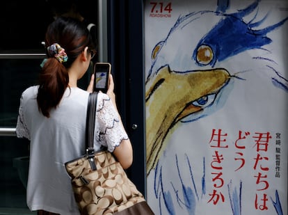 Una mujer toma una fotografía del póster de la nueva película de Miyazaki en un cine en Tokio el 14 de julio de 2023.
