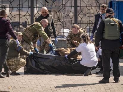 Ukrainian soldiers clear out bodies after a rocket attack killed at least 35 people on April 8, 2022 at a train station in Kramatorsk, eastern Ukraine, that was being used for civilian evacuations. (Photo by FADEL SENNA / AFP)