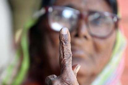 Una mujer india muestra su dedo marcado con tinta tras votar en las elecciones a la Asamblea del estado indio de Madya Pradesh, en Bhopal (India).