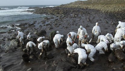 Un grupo de voluntarios limpia el chapapote, en los alrededores del cabo Touriñán (A Coruña), en diciembre de 2002.