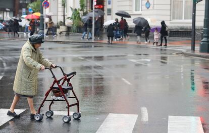 Una pensionista cruza un paso de cebra en Bilbao.