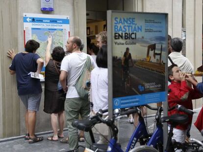 Turistas visitan la entrada de la oficina de San Sebastián Turismo