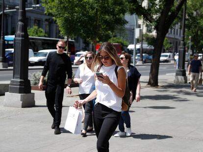 Usuaria de telefonía móvil en una calle de Madrid.