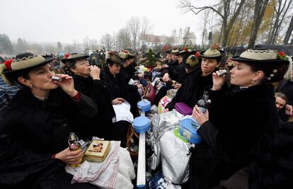 Un grupo de mujeres vestidas con ropas tradicionales y sentadas en un carruaje brindan con sus copas de 'schnapps' durante la peregrinación tradicional 'Leonhardifahrt' en Bad Toelz, Alemania.