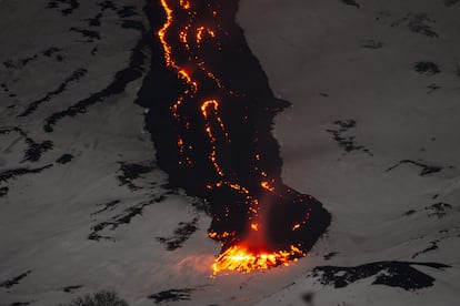 Una lengua de lava avanza sobre la nieve, vista desde Adrano (Catania), el 11 de febrero.