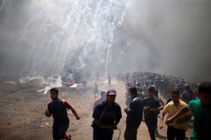 Un grupo de palestino corre durante el lanzamiento de botes de gas lacrimógeno por parte del Ejército de Israel en la frontera, el 14 de mayo de 2018.