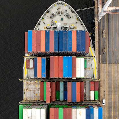 TOPSHOT - This aerial view shows a cargo ship carrying shipping containers moored to the pier at the Port of Baltimore on April 10, 2025, in Baltimore, Maryland. US President Donald Trump's 10 percent tariff for almost all countries except China will likely remain in place going forward, his top economic advisor Kevin Hassett said Thursday. On April 8, Trump announced a 90-day pause on higher tariffs against all countries except China, reversing a policy that had roiled global stock markets and spooked the American bond markets -- a key barometer of investors' faith in the US government's ability to pay its debts.