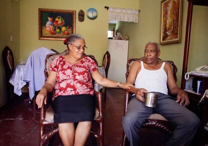 Domitilia toma la mano de su pareja, Salvador, en su casa en Santo Domingo, República Dominicana. A los 57 años, Domitila tiene diabetes, pero ella se recuperó satisfactoriamente de la tuberculosis después de dos años de tratamiento.