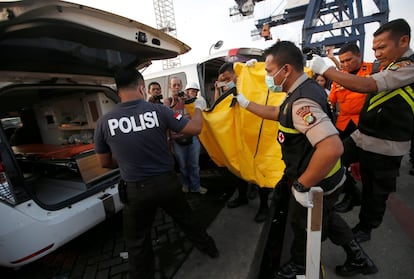 Miembros del equipo de rescate llevan una bolsa con los restos de un pasajero del vuelo JT610 de Lion Air, en el puerto de Tanjung Priok, en Yakarta.