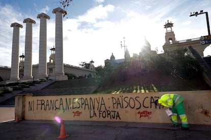 Personal de limpieza limpia las pintadas y carteles de las inmediaciones del Museo Nacional de Arte de Cataluña (Barcelona).