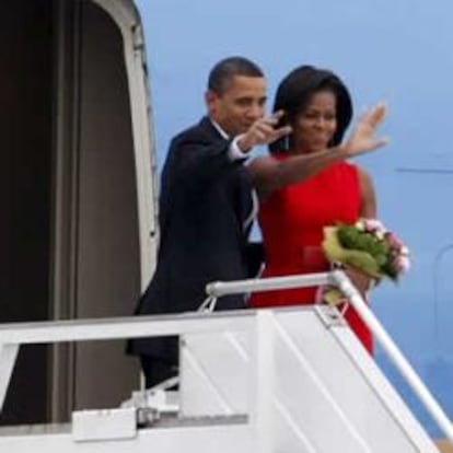 El presidente estadounidense, Barack Obama, y su esposa, Michelle, saludan antes de subir a bordo del Air Force One y emprender su viaje a Italia