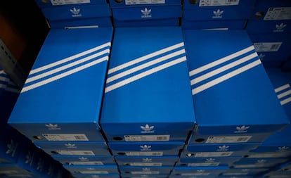 Cajas apiladas de zapatillas Adidas, con el diseño de las tres rayas.