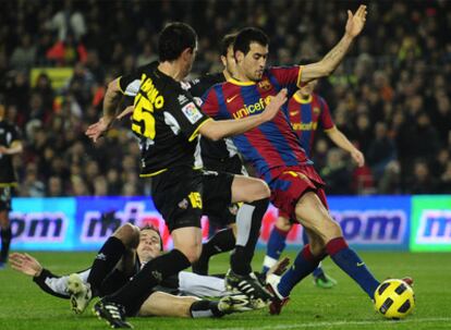 El centrocampista del Barcelona Sergio Busquets disputa un balón ante la presión del defensa Del Horno, del Levante, en el choque de ida entre el club azulgrana y el equipo valenciano.