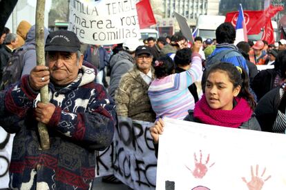 Un hombre mayor con una bandera se manifiesta junto a una niña que sostiene una pancarta. El conflicto ecológico afecta a toda la región de forma transversal y personas de todas las generaciones sufren sus consecuencias.